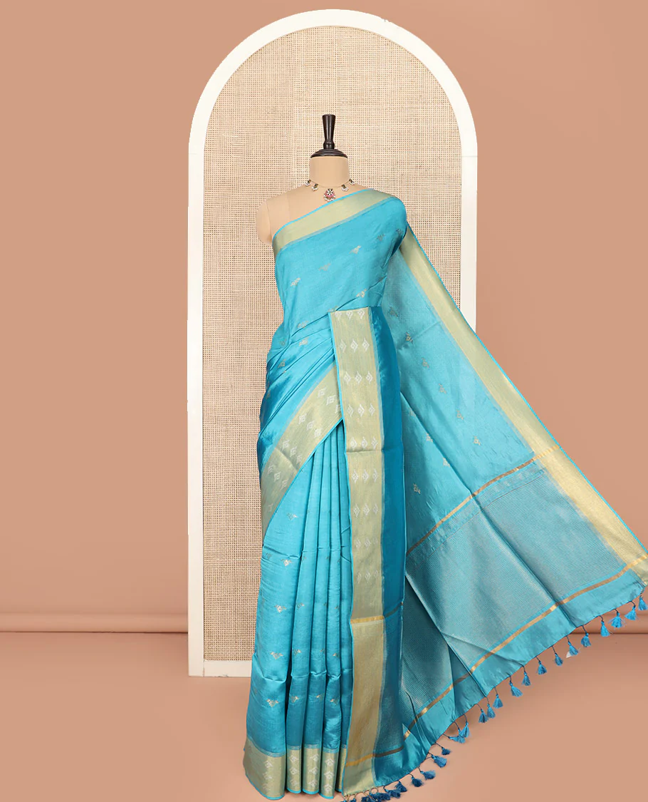Blue Banana Pith Saree Elegantly Framed with Zari Buttas, Artfully Detailed Border with Zari Designs, Gleaming Zari Stripes Woven Pallu, and Paired with a Matching Plain Blouse