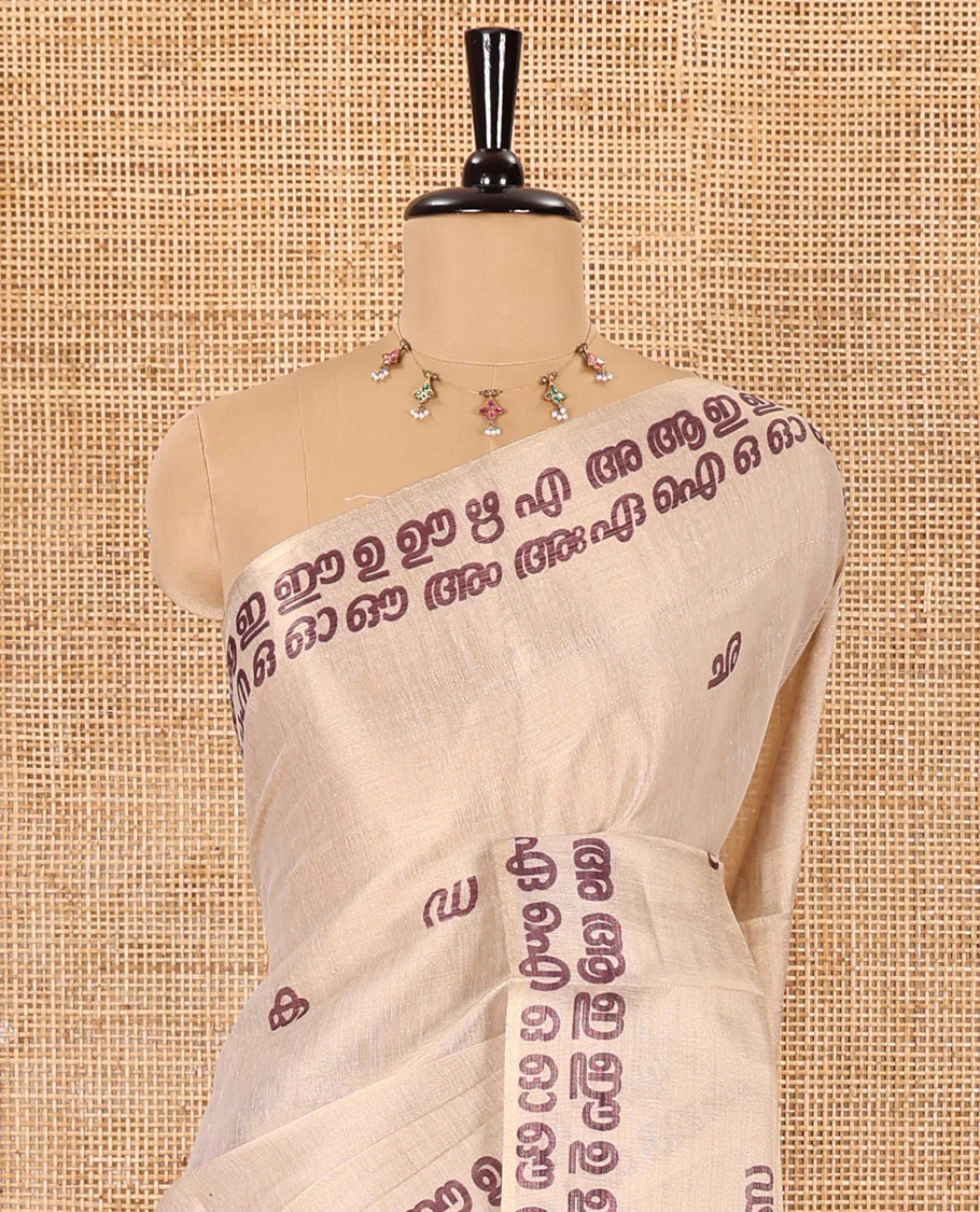 Cream-magenta Malayalam letter printed tissue saree, self-border and pallu steeped with Malayalam letter motifs, and a contrast plain blouse - Image 3