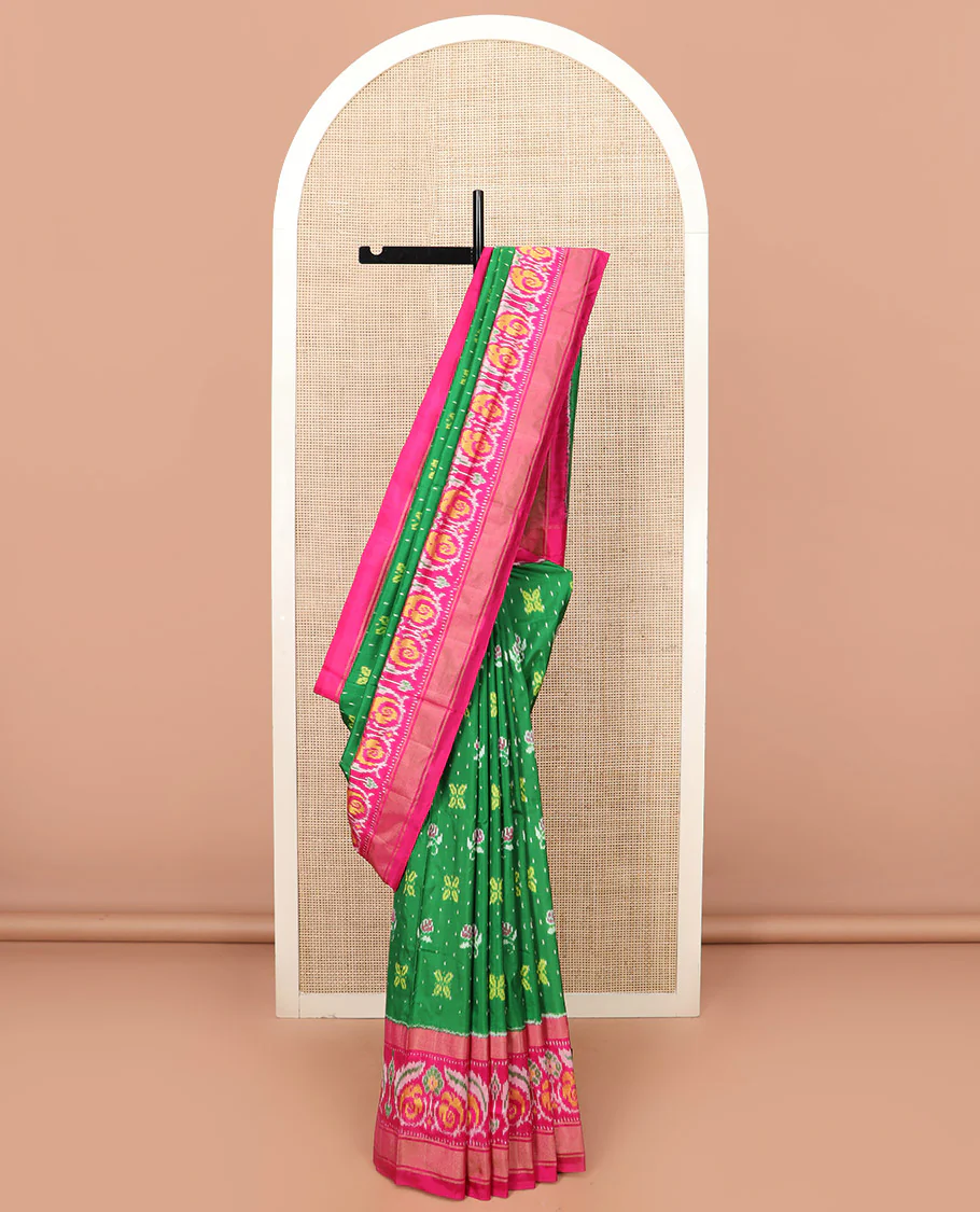 Green Ikkat silk saree features floral Ikkat buttas, highlighted with a contrast Ikkat woven border, a hazily woven Ikkat patterned pallu, and a contrast blouse - Image 2