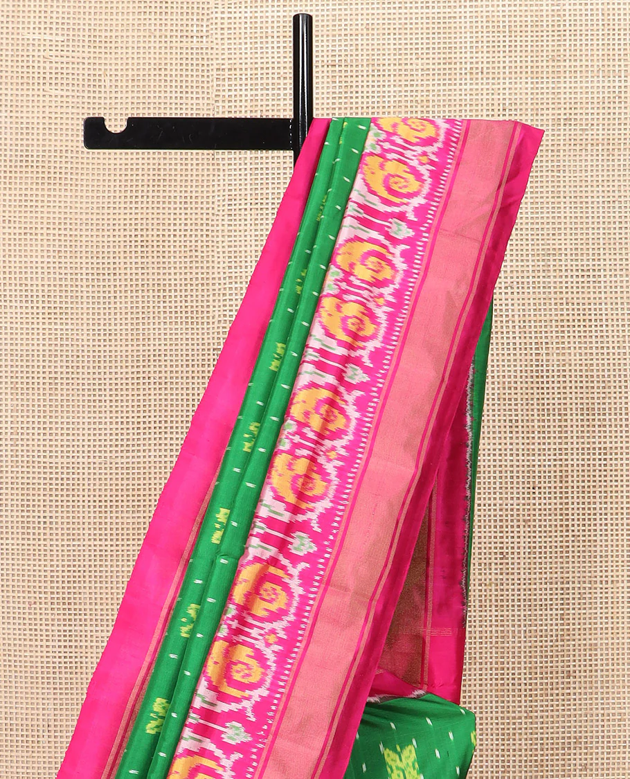 Green Ikkat silk saree features floral Ikkat buttas, highlighted with a contrast Ikkat woven border, a hazily woven Ikkat patterned pallu, and a contrast blouse - Image 3