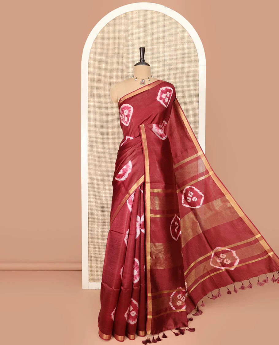 Maroon Banana Pith Saree Elevated with Bright Shibori Print, Subtly Woven Zari Bavanji Border, Pallu Featuring Shibori Print, and Paired with a Matching Shibori Printed Blouse