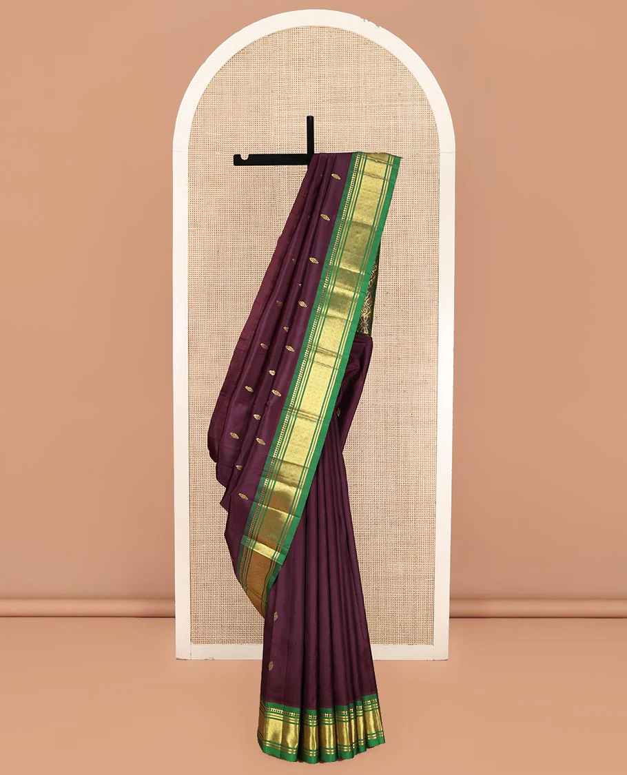 Maroon Kanchipuram Silk Saree, Spotlighted with Zari Buttas on Its Body, Complemented by a Contrast One-Sided Border of Panner Sombu, Banaras, and Jaal Designs, Pallu Features Floral Zari Designs, and Comes Without a Blouse