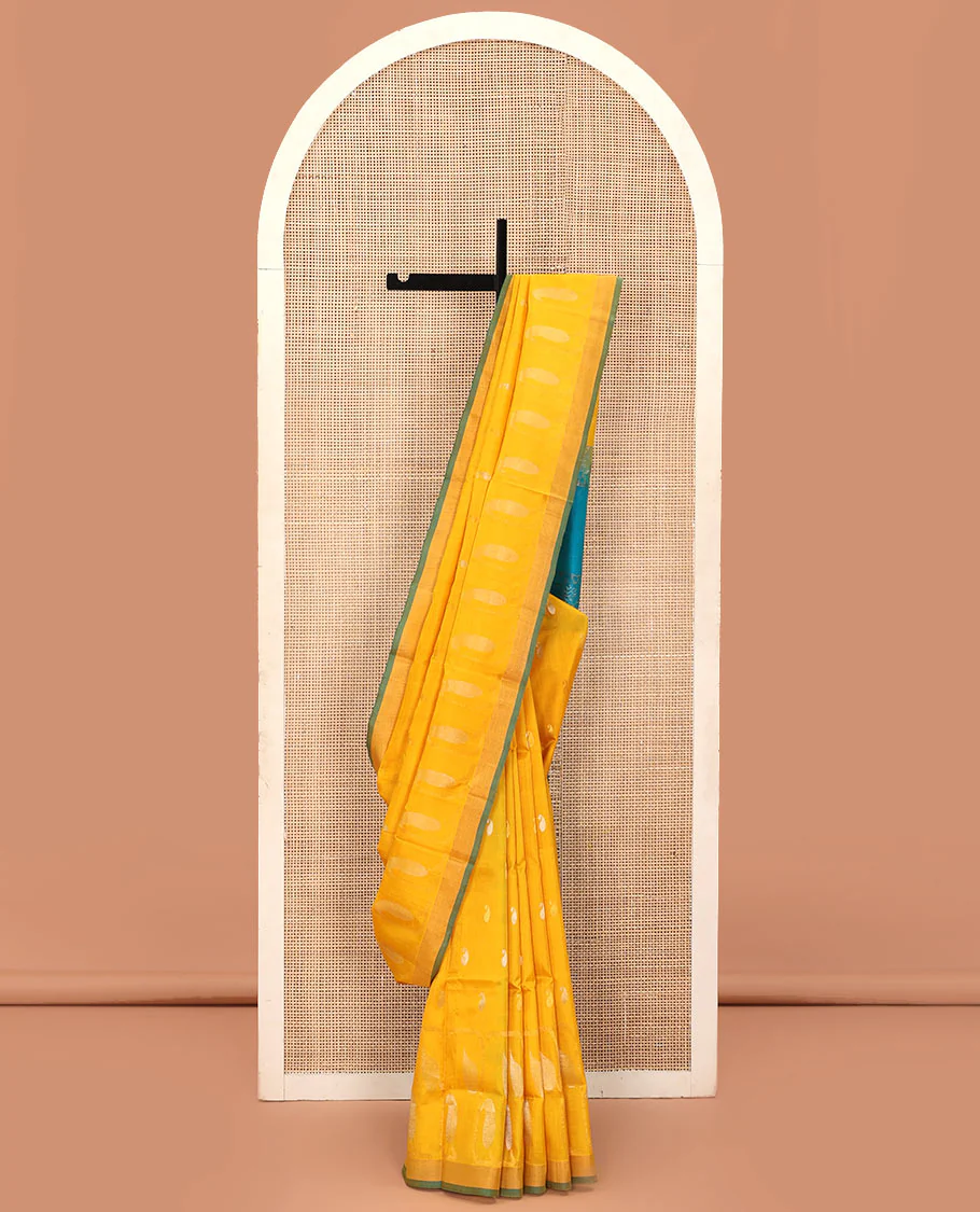 Yellow Uppada Silk Saree Gracefully Embellished with Zari Buttas and Paisley Buttas, Subtle Bavanji Border, Complemented by Contrast Pallu of Peacock Designs, and Paired with a Contrast Blouse